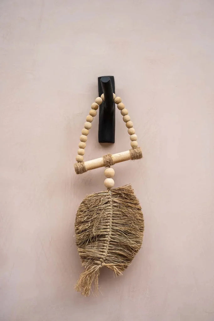 Suspension murale en macramé avec des perles en bois.