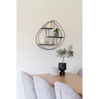 Étagère murale en métal noir avec cadre ovale abstrait et trois étagères décalées