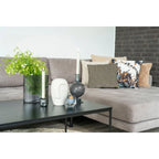 Canapé sectionnel gris avec coussins rayés et floraux, design moderne