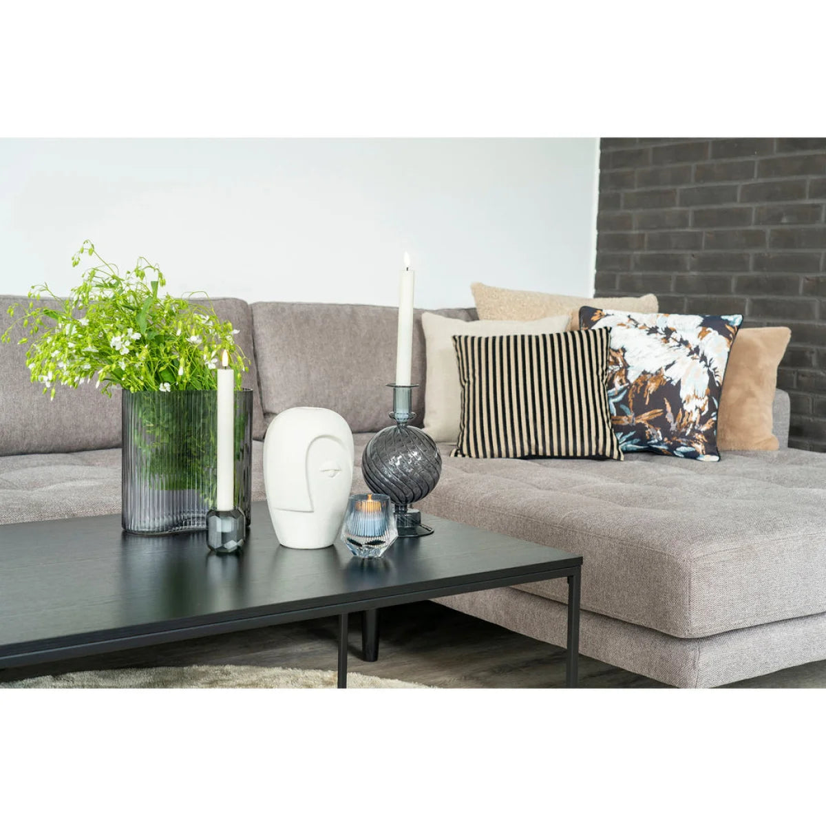 Canapé sectionnel gris avec coussins rayés et floraux, design moderne