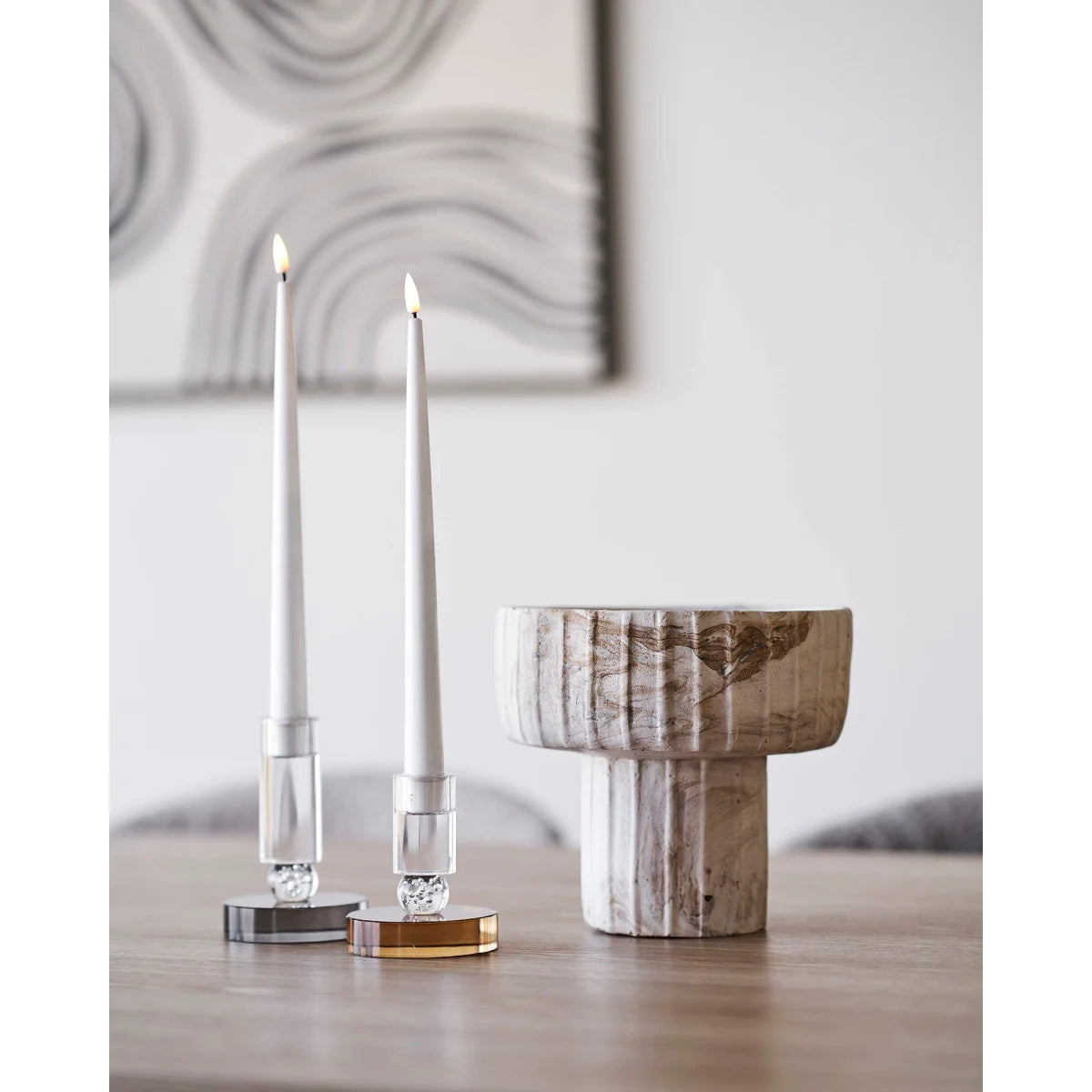 Bougie allumée dans des bases en verre et métal avec un bol en marbre blanc