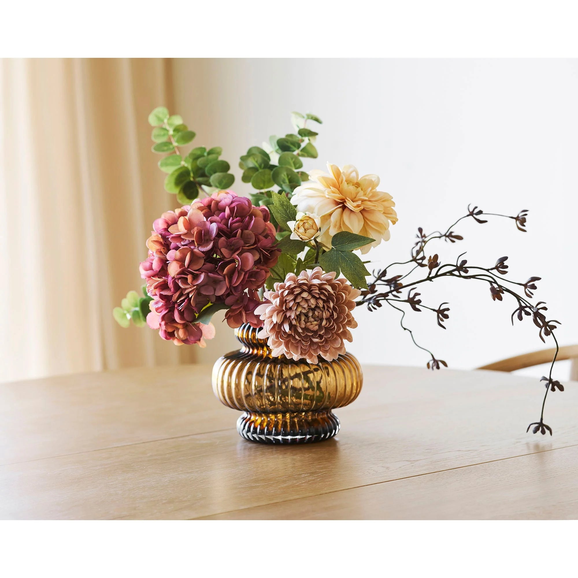 Arrangement floral décoratif dans un vase en verre ambré relief fluté forme citrouille