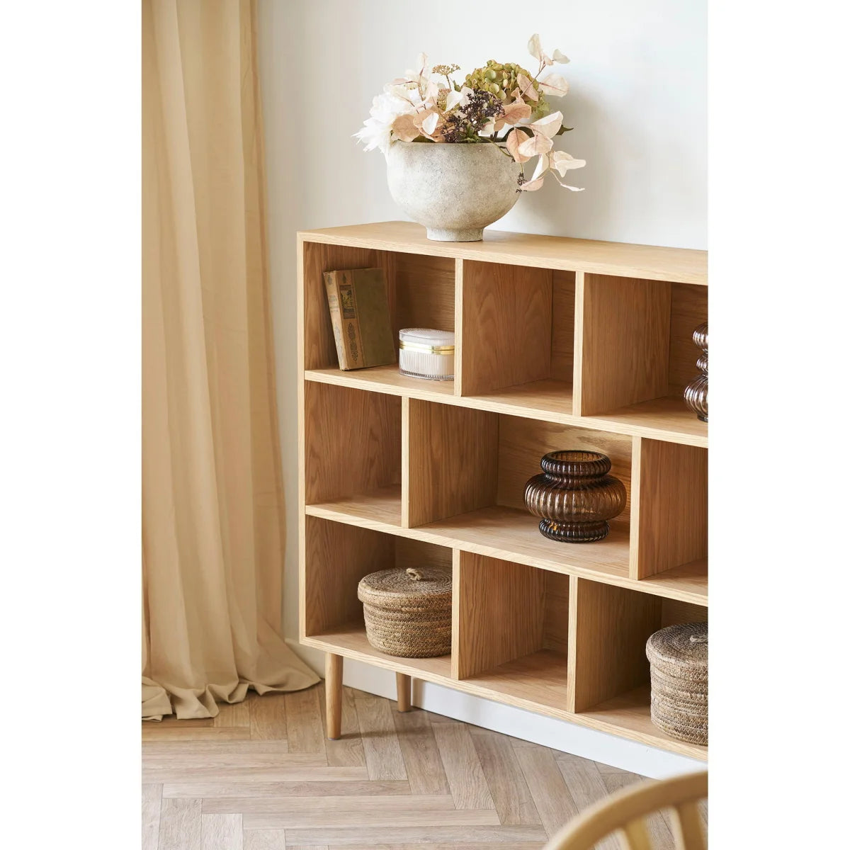 Étagère cube bois clair pieds fins avec vase citrouille verre fumé ambré