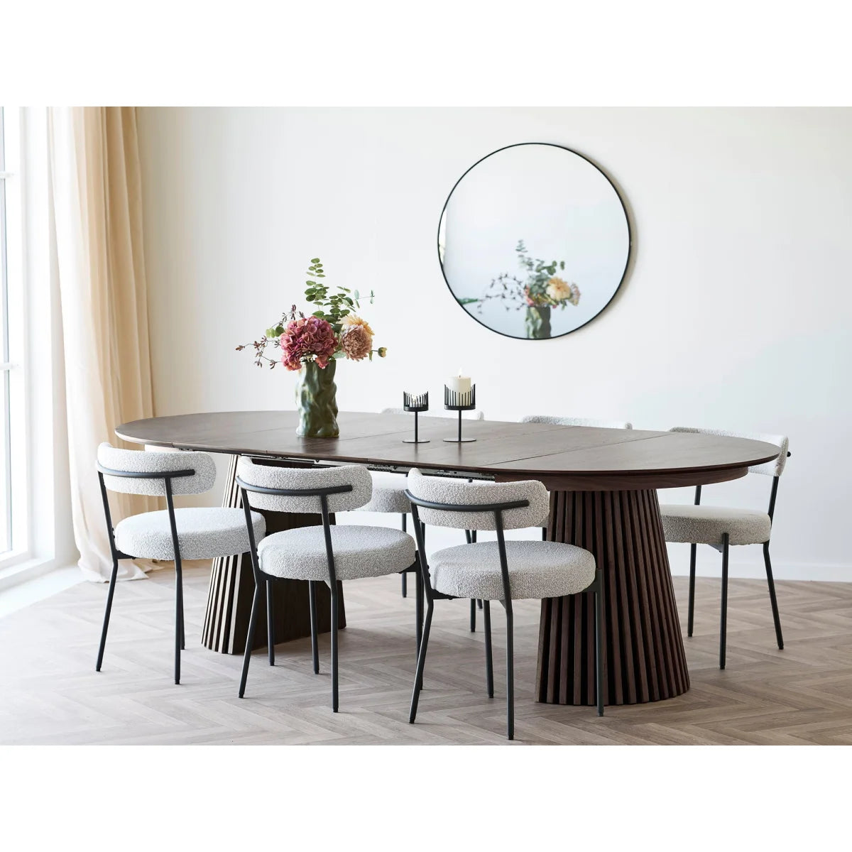 Table à manger ovale avec six chaises rembourrées blanches et vase décoratif en céramique vert olive
