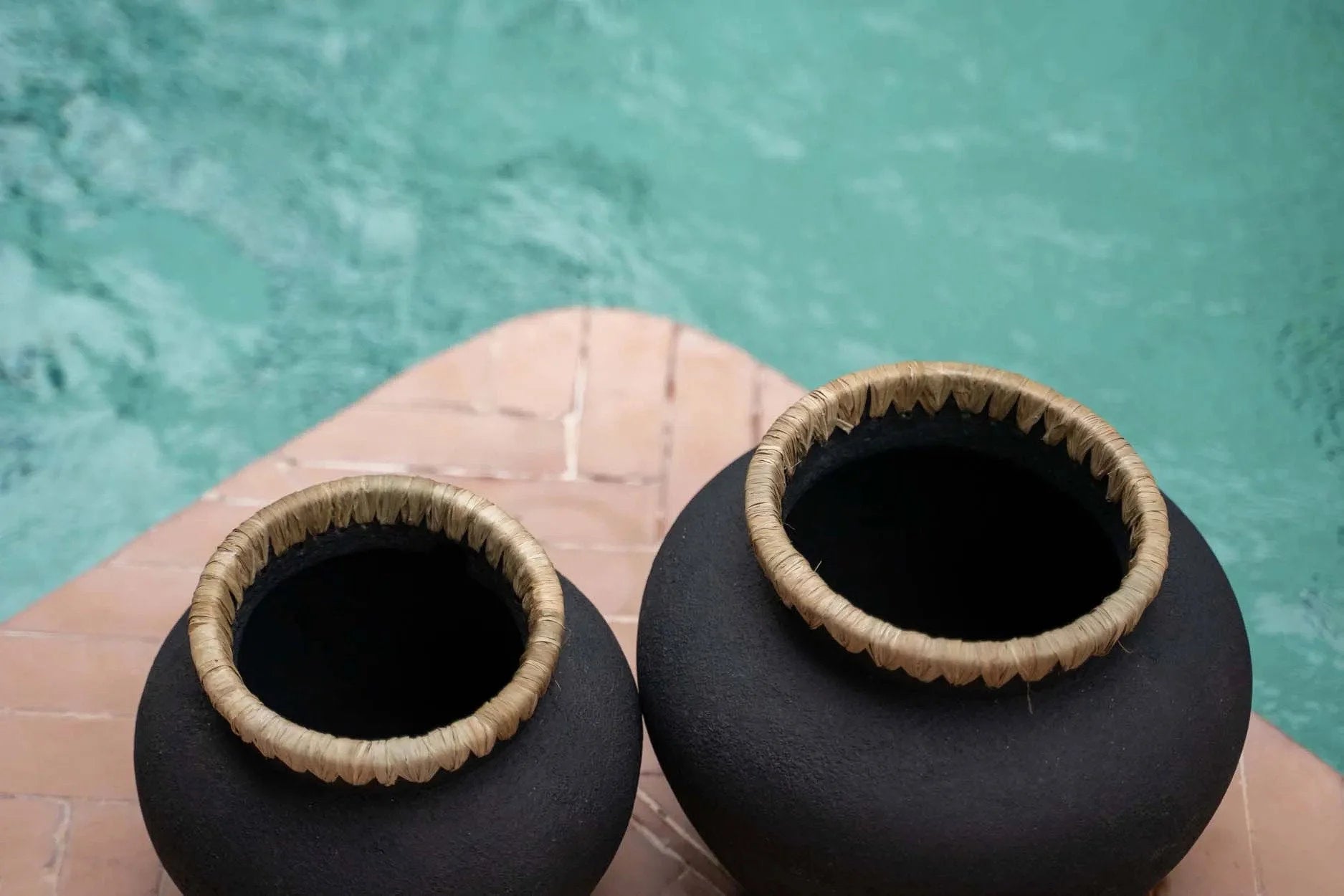 Deux pots en terre cuite noires avec bords en paille tissée, décoration élégante