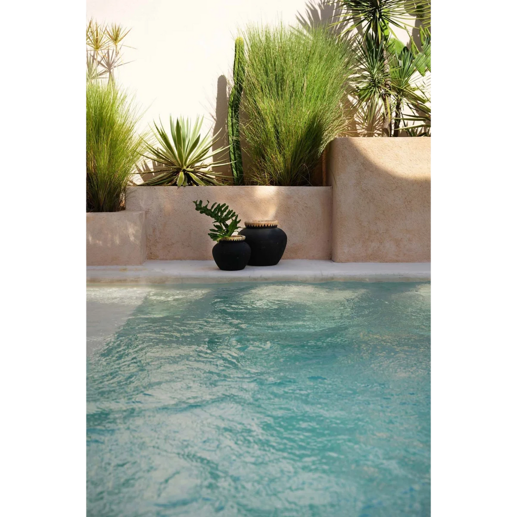 Vase décoratif noir en terre cuite Ø33 cm avec reflet d’une piscine calme et bleue pâle