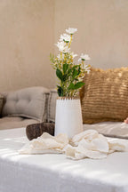 Arrangement floral de marguerites blanches dans un vase en terre cuite avec raphia