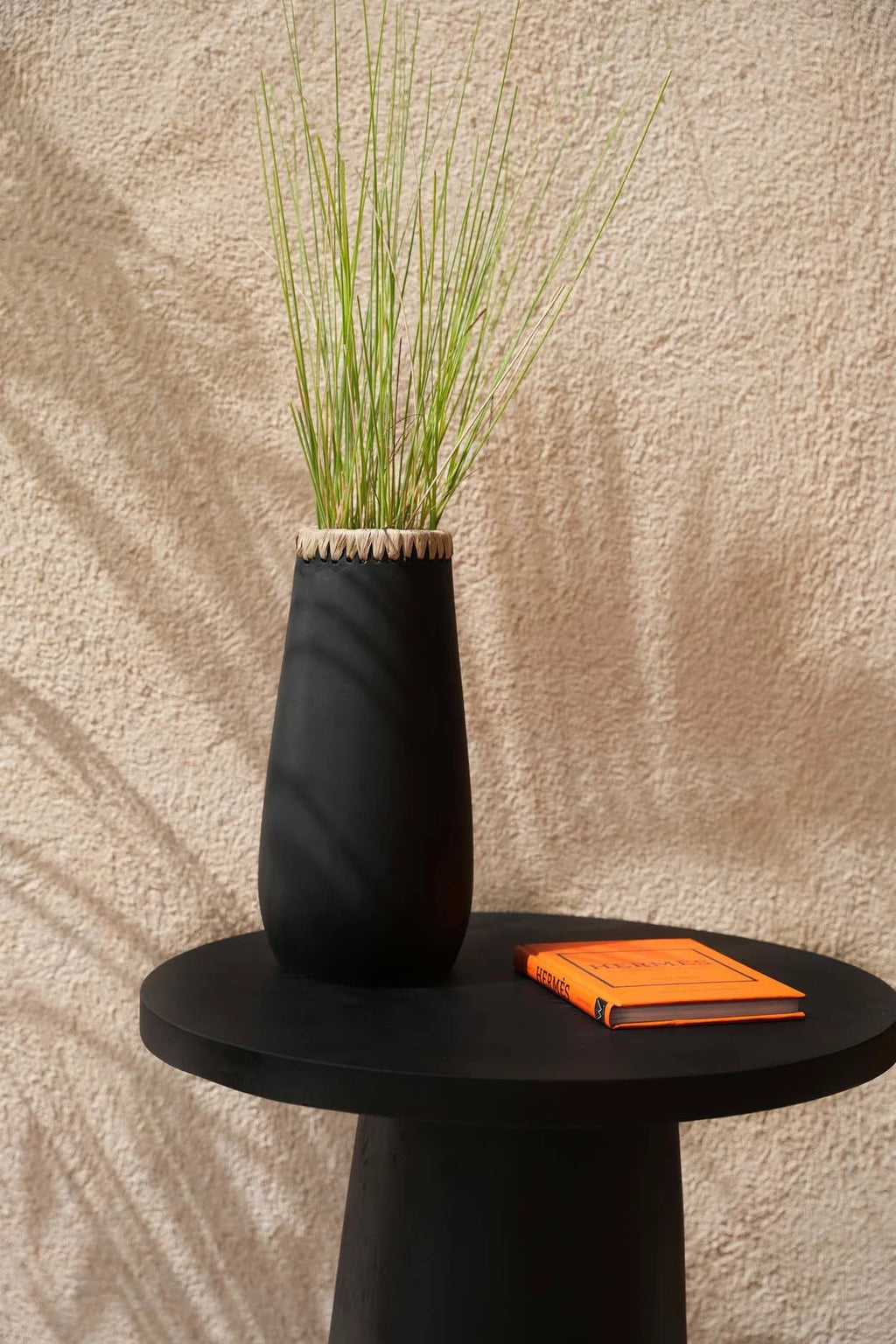 Vase décoratif en terre cuite noir avec herbe ornementale verte pâle