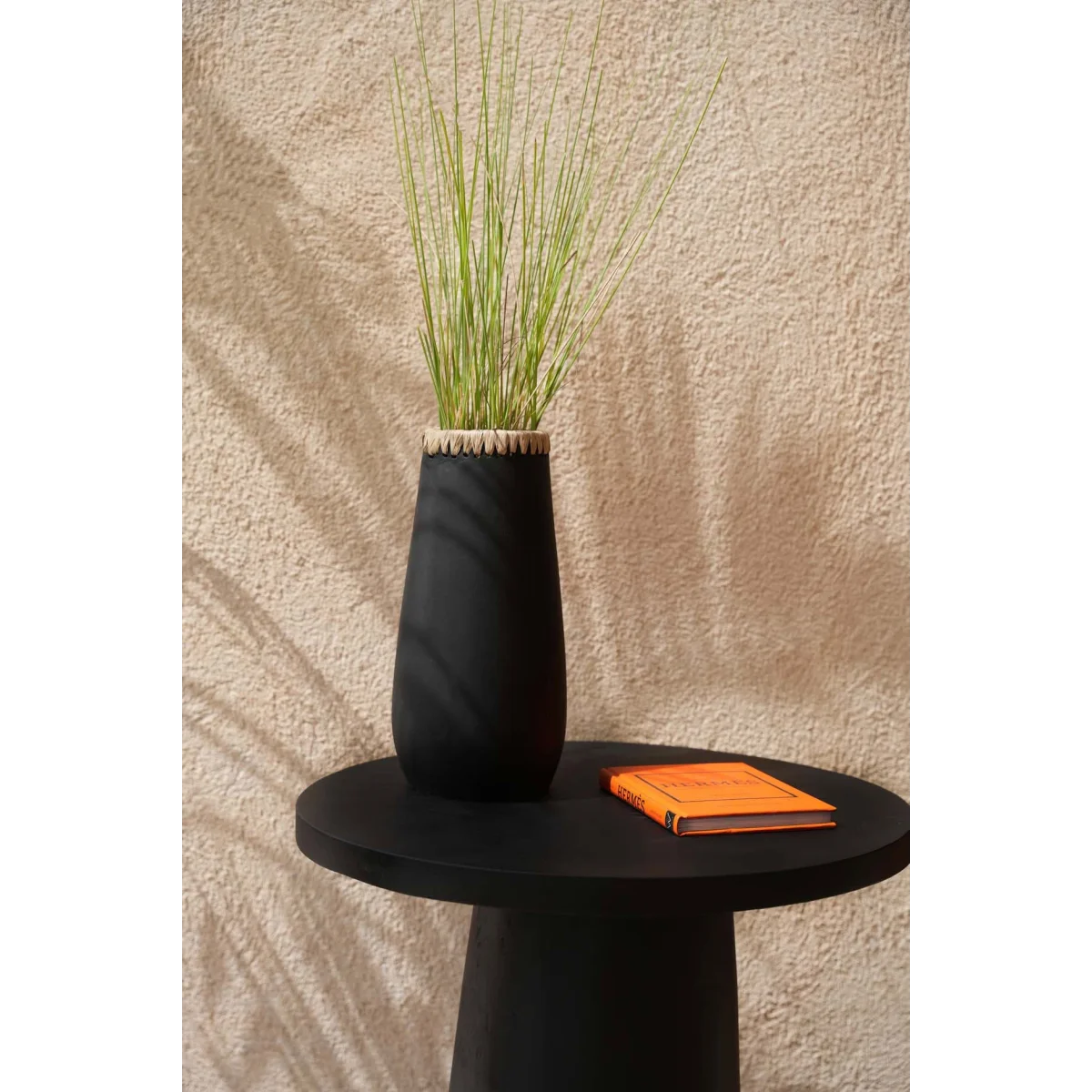 Vase décoratif en terre cuite noir avec herbe ornementale verte pâle