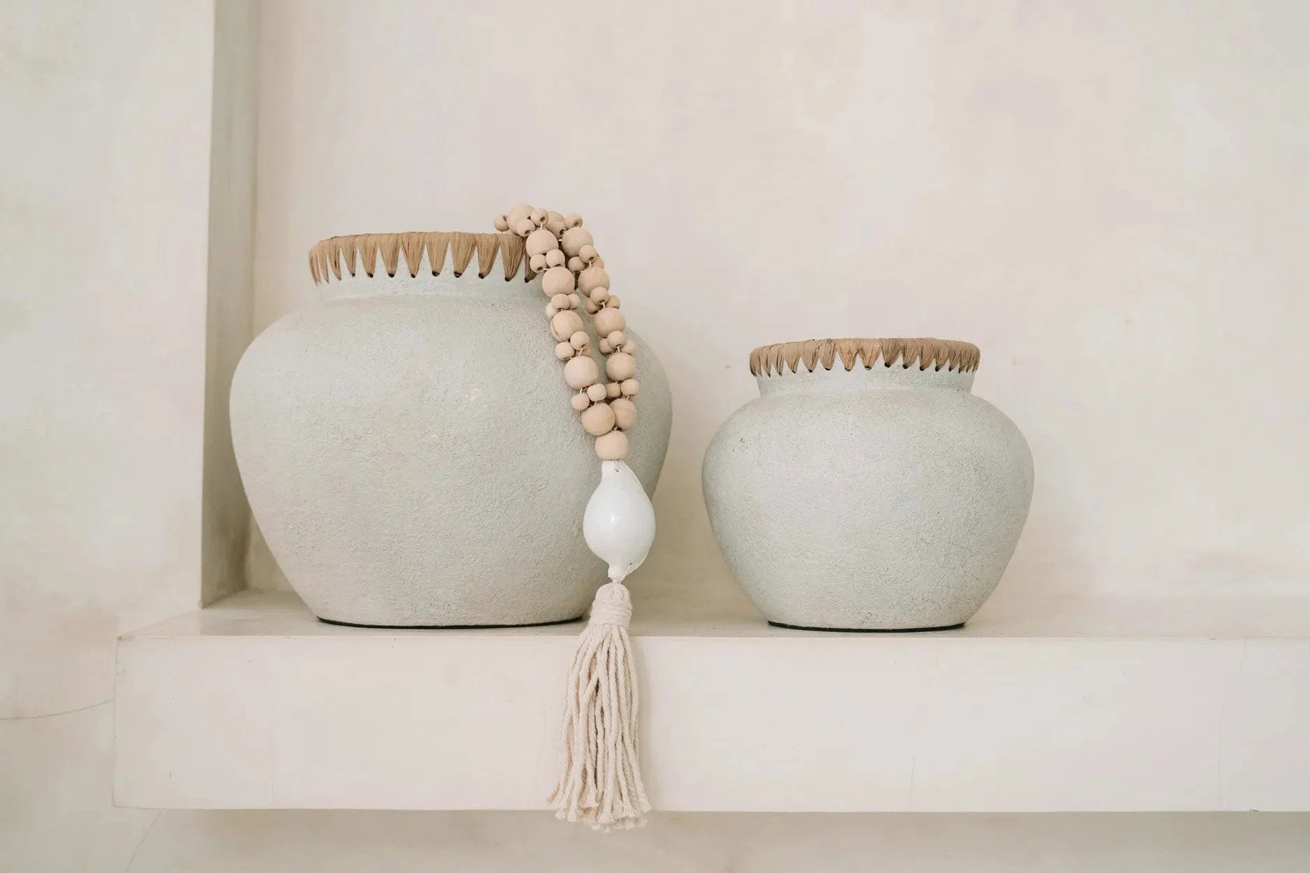 Vase décoratif en terre cuite et raphia avec vases gris clair, textures, bois et tassel