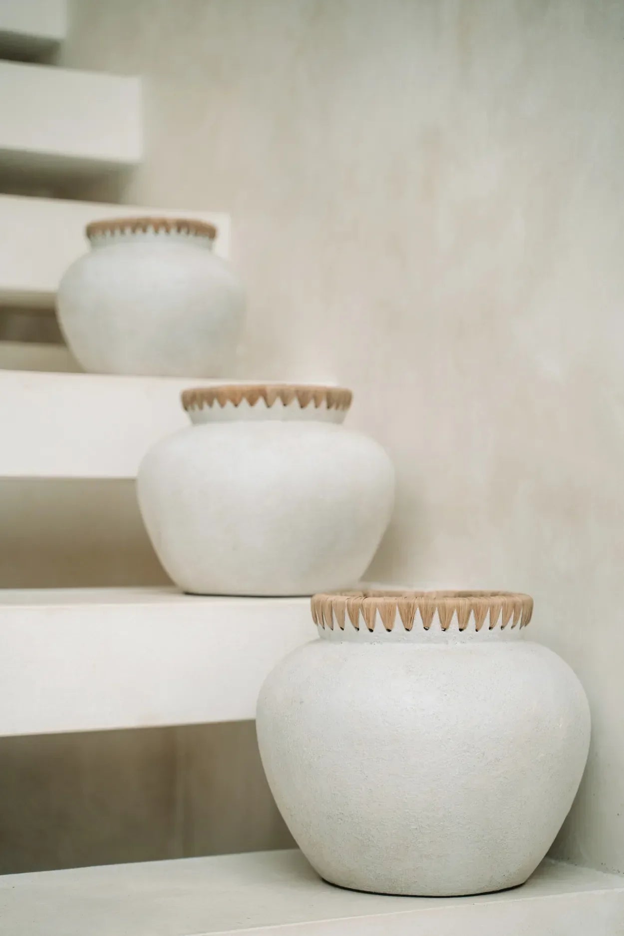Trois pots en céramique blanche avec finition en raphia, décoratif en béton naturel