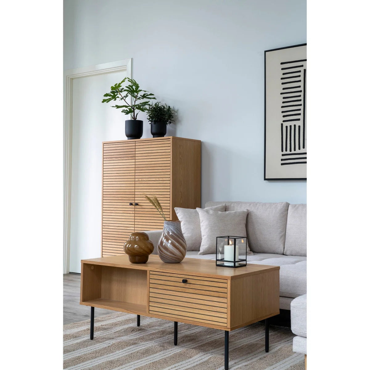 Table basse en bois clair à lattes, pieds métal noir, tiroir unique