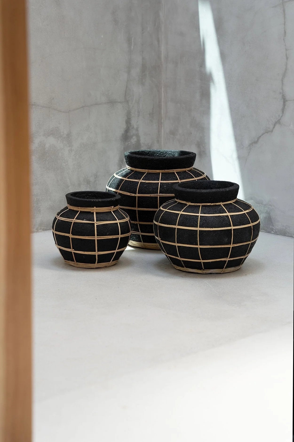 Trois vases noirs en terre cuite avec grille en rotin, H23 cm, décoration élégante
