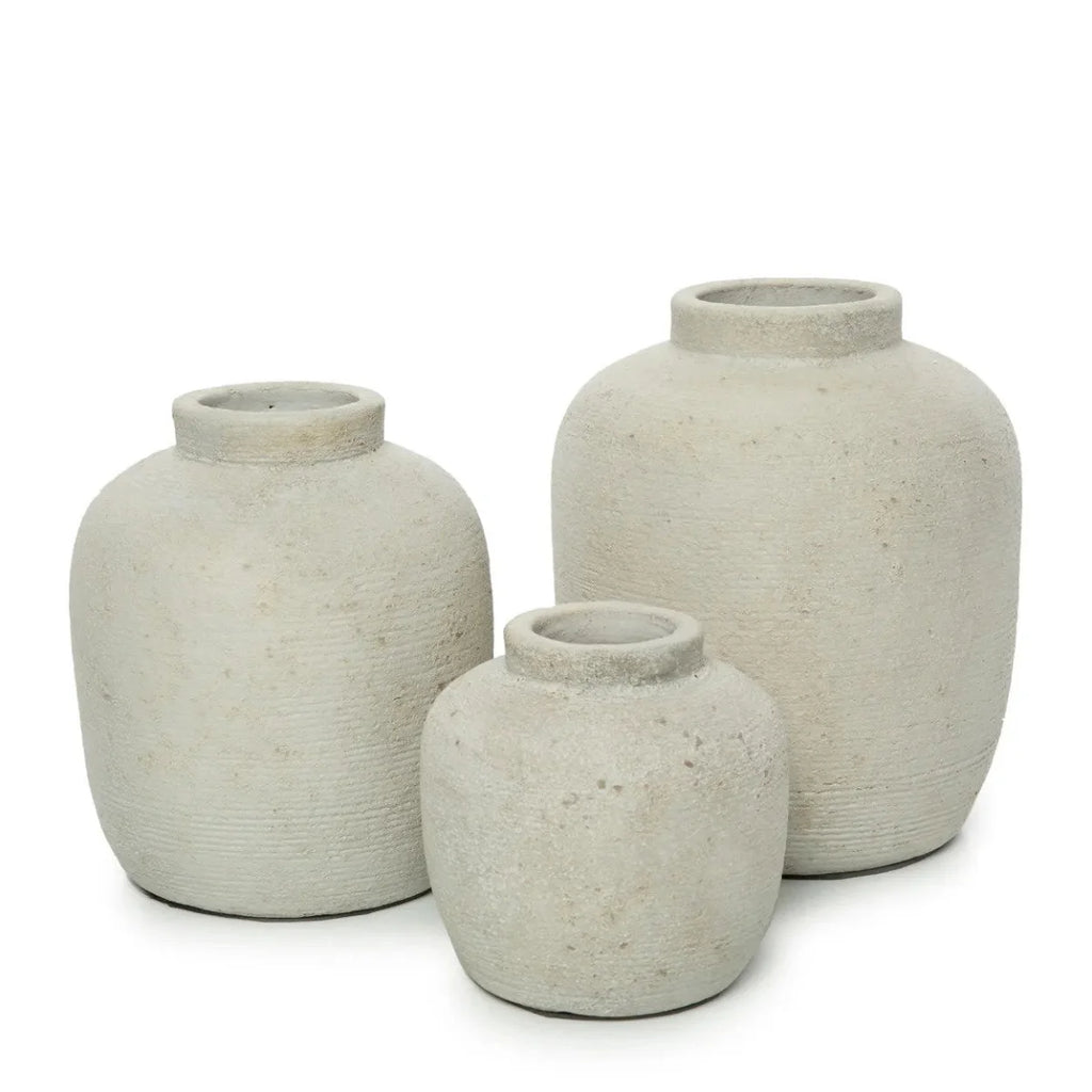 Vase rond en terre cuite beige mat avec trois vases gris texturés et ouverts fins