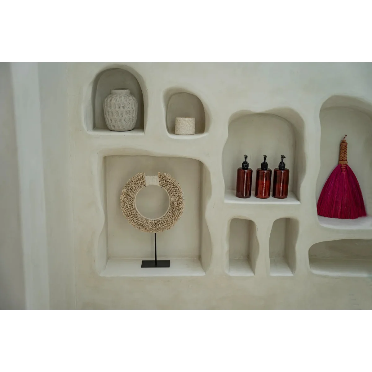 Vase rond en terre cuite gris effet béton avec étagères décoratives et objets variés