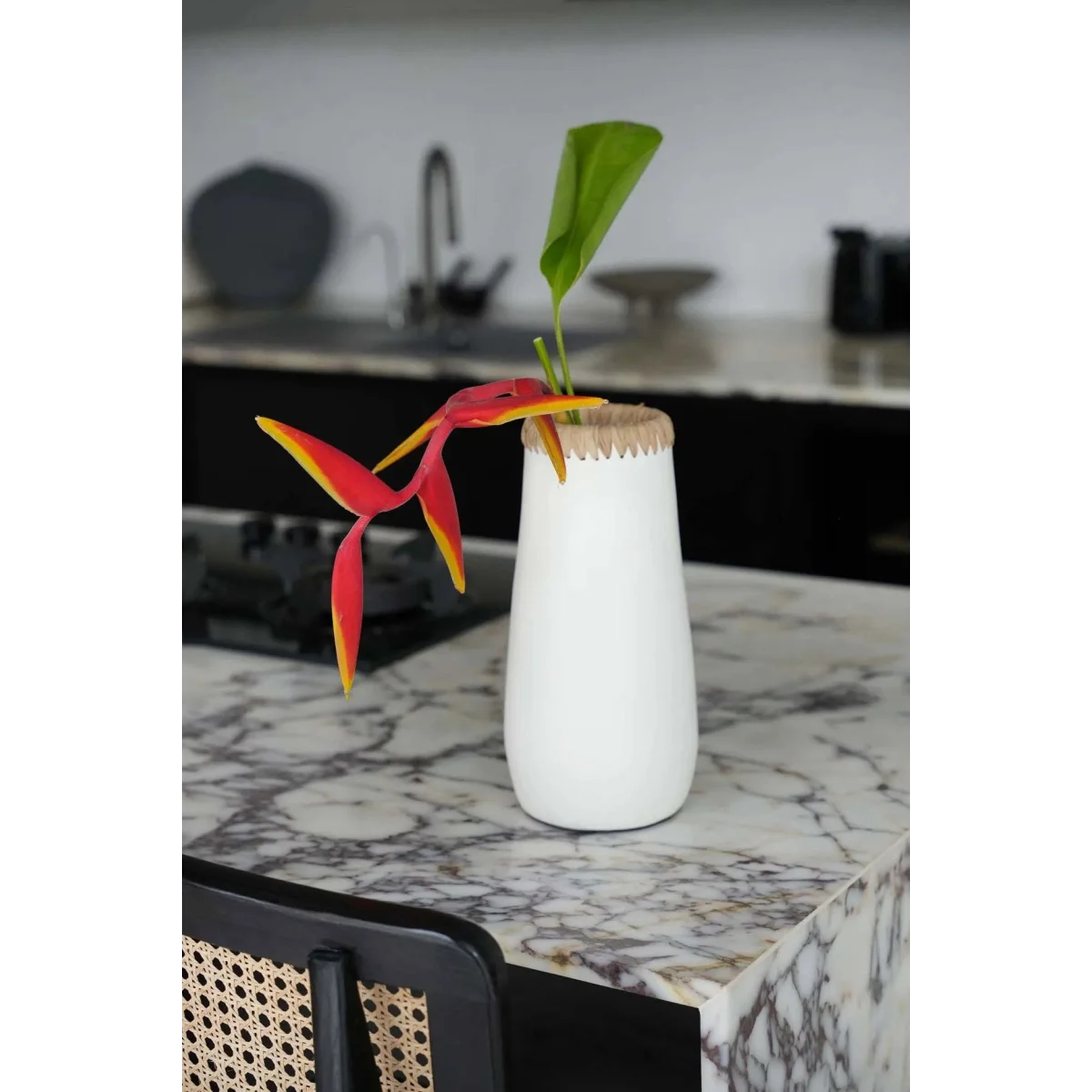Vase en terracotta blanc naturel avec fleur de paradis rouge jaune et feuille verte