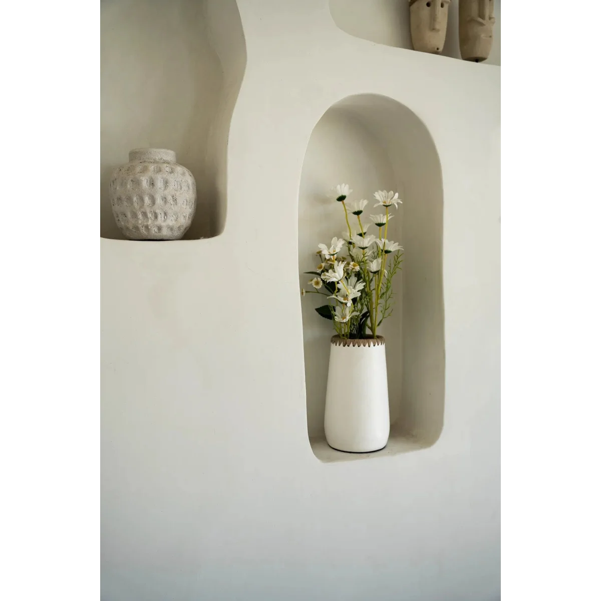 Vase en terre cuite blanc avec bouquet de fleurs daisies blanches et bord tressé en raphia