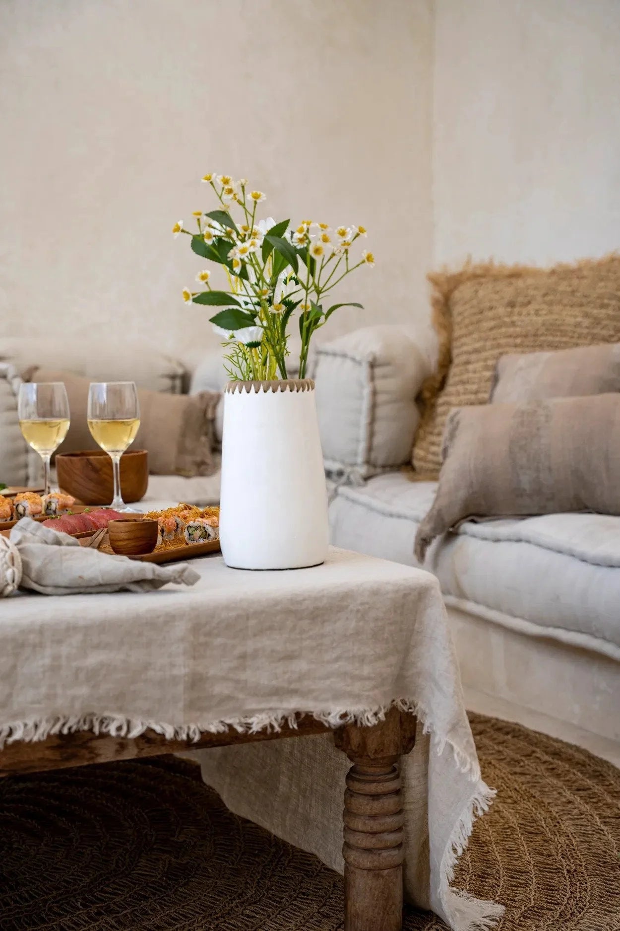 Vase en terre cuite blanc avec bord tressé en raphia et fleurs élégantes