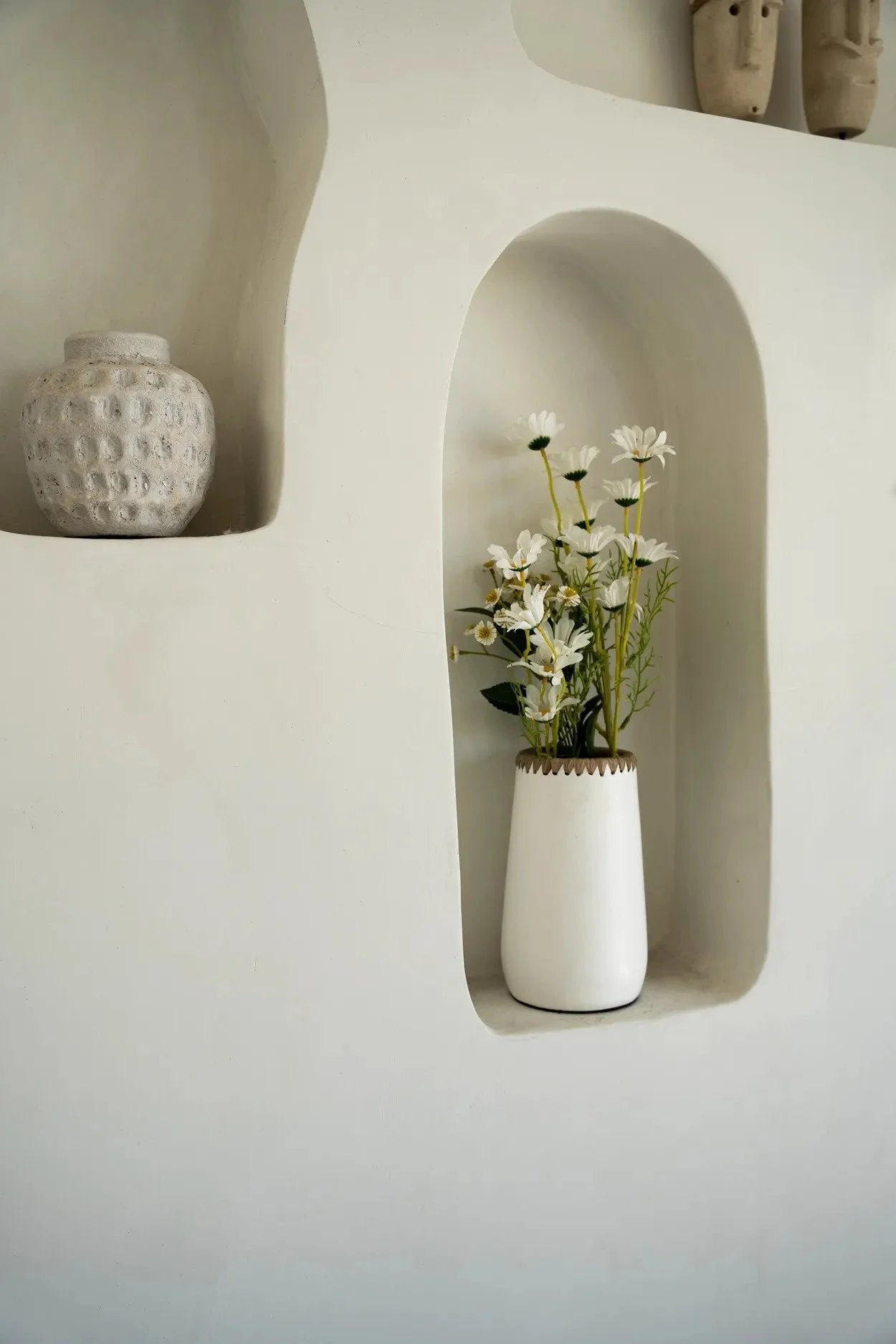 Vase en terre cuite blanc avec bord tressé en Raphia rempli de marguerites