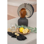 Vase en terre cuite noir à texture côtelée tenant des ustensiles en bois et un trivet tissé