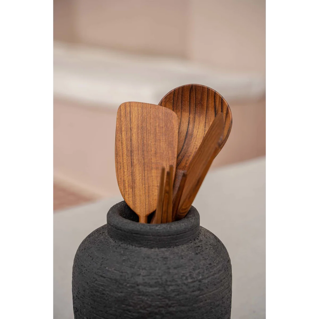 Vase en terre cuite noir texturé avec ustensiles de cuisine en bois