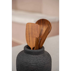 Vase en terre cuite noir texturé avec ustensiles de cuisine en bois