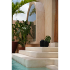 Escaliers extérieurs menant à une piscine avec plantes décoratives et miroir, vase en terre cuite noire