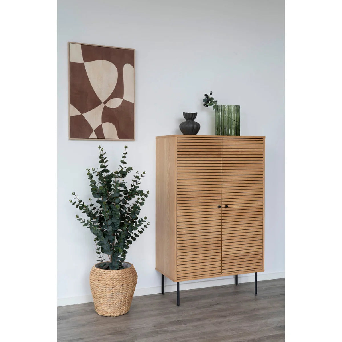 Vase en verre vert cannelé ondulé H26,5 cm sur meuble bois naturel