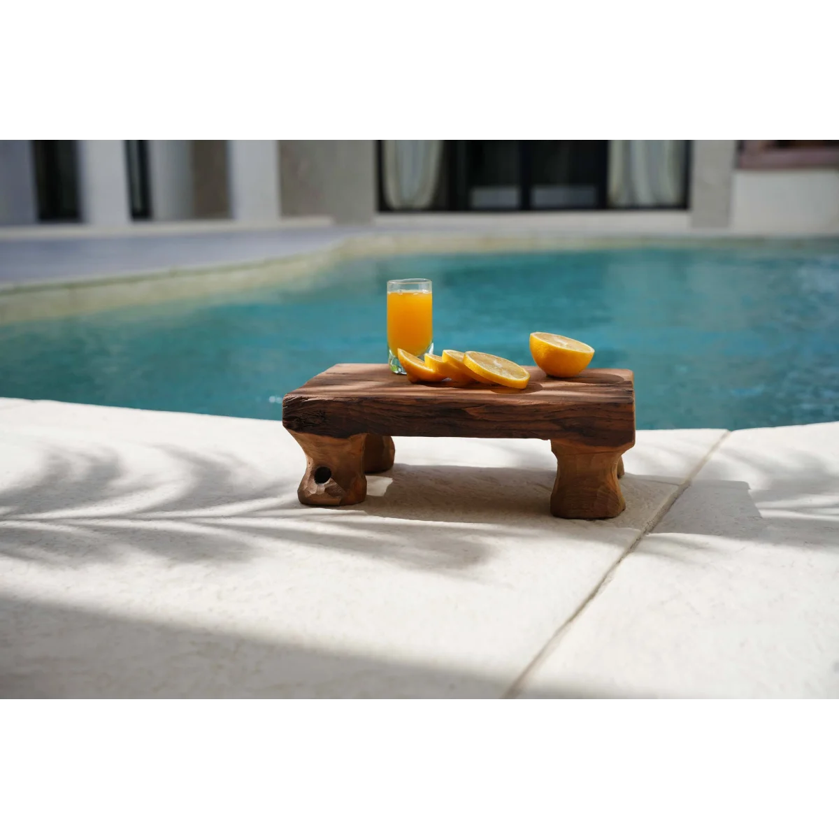 Verre à shot en verre recyclé avec tranches d’orange et jus au bord de piscine