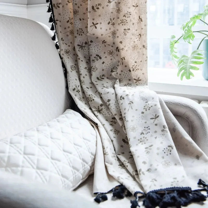 Gros plan sur les franges noires du voilage vintage.

